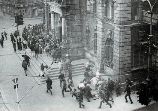 Lidé prchají před střelbou sovětských okupantů u liberecké radnice, 21. srpna 1968. Foto: Václav Toužimský.