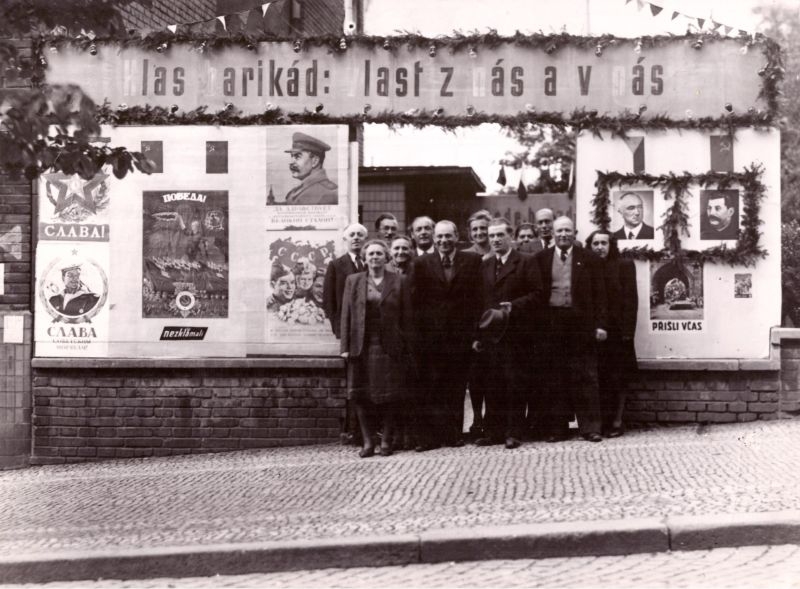 V Radhošťské ulici v roce 1946, první výročí osvobození, vlevo domovnice paní Řezáčová, za ní pan Řezáč, Marie Baranová za nimi uprostřed. Zdroj: Paměť národa / archiv pamětnice