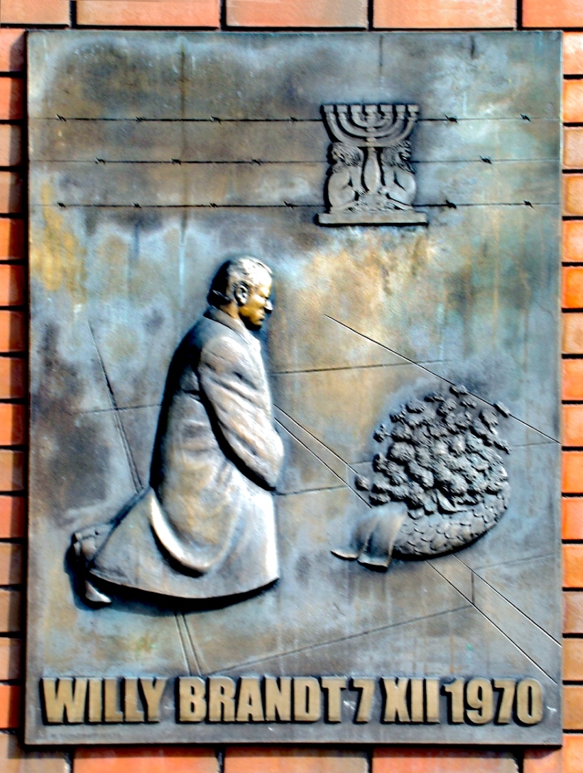 Plastika připomínající tzv. Varšavské pokleknutí, symbolický akt německého kancléře Willyho Brandta, který při návštěvě Varšavy 7. prosince 1970 padl na kolena před pomníkem hrdinů tamního ghetta. Zdroj: Wikipedie