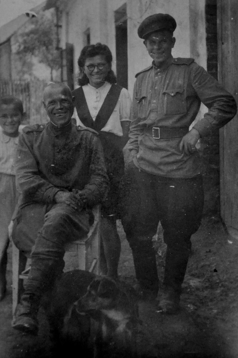 Irena Ondruchová, bratranec Luboš Adámek a pes Alík s ruskými vojáky ve Výškovicích v květnu 1945. Foto: Paměť národa