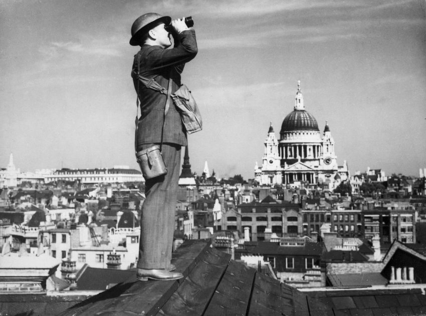 Jeden z dobrovolných pozorovatelů na londýnské střeše během bitvy o Británii. V pozadí kupole katedrály sv. Pavla, která jako zázrakem zůstala netknutá, ačkoli Luftwaffe Londýn zasypávala zápalnými bombami každou noc.