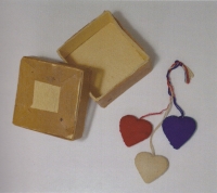 Wooden hearts, dressed in scraps of cloth in tricolour – handcrafted by the prisoners in Svatobořice. These and other products were hidden in a metal box buried next to the prison house for four and a half years. The prisoners unearthed the box just before their release.