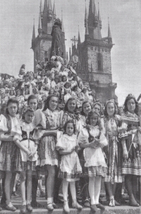 At the base of Hus Monument in Old Town Square on 17 May 1945 (first row, third from the right). The people are waving to the returned legionaries, who were marching by during a celebratory parade. One of them was Mrs Tůmova’s father, but they did not know of each other’s presence at the time (photo source: Oldřich Smola, “Srdce Prahy v plamenech”, 1946).