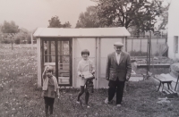 Pamětnice (uprostřed) se sestrou Ivetou a dědou Tomášem u skleníku, který sestrám postavil, Mříčí (Křemže), konec 70. let