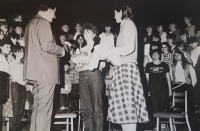 Pamětnice (dívka vlevo) - dle zvyklosti - předává chléb a sůl hostujícímu Eduardu Hakenovi při koncertu Pěveckého sboru jihočeských učitelek v Týně nad Vltavou, 1985