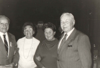 Iveta's photograph from one of those semi-illegal reunions of the RAF airmen from the whole country which were organised during the second half of the 1980's. These reunions were organised under the auspices of the Socialist Youth Union in Kolín. The main organiser was JUDr.  Jiří Sehnal. His mother is on the right from Jan Irving, at far left, Alois Konopický. (Iveta could not remember the name of the lady in the white sweater after all those years.)
Everyone was looking forward to these yearly reunions. The secret police was was busy with that many irons in the fire and they couldn't manage to note down everything about the groups moving from the railway station or arriving in cars from all over Czechoslovakia. The cops drove in their Lada and Skoda cars to and fro and even the reinforcements did not help. It was certainly a sight to see when tens of people with tricolour ribbons on their lapels showed. The airmen and their families were aware of this and they indulged in the Schadenfreude. (Iveta, a stubborn teenager, would bravely stick her tongue out at them when they appeared.) When everyone met in the hall of the Cultural Centre, they had a lunch and then there were debates, stories told and Iveta started making notes about specific stories for her book about Ant the dog which she had already started writing. 
In 1989, with the help of Jan Irving and a few others, they started fundraising and organising for a reunion for the 50th anniversary of the Battle of Britain in the United Kingdom. It was in fact illegal for the Czechoslovaks so it appeared to be just vain dreaming even though the British side was involved as well as the Union of Czechoslovak Foreign Airmen with their headquarters in London and several other organisations.