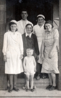 Miroslav Tupý (chlapec vpředu) s oběma rodiči (vlevo) a prodavačkami z obchodu, který vedl jeho otec