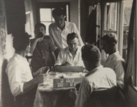 Václav Fořt u stolu při společenské hře, kterou nazývali Žulík. Hrálo se s mramorovými destičkami