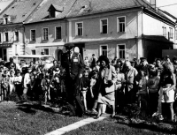 Vojenský přidělenec USA John Motyka s manželkou kráčejí k památníčku U.S. Army na plánském náměstí před obchodním domem za účasti obyvatel a čestné stráže skautů, květen 1990