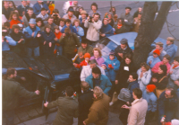 Václav Havel nastupuje do auta po návštěvě Hradce Králové, u stromu v černém plášti s připnutou legitimací organizátora R. Novák, leden 1990