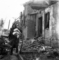 Babička Antonie Barborková zachraňuje majetek z trosek domu v dubnu 1945