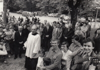 Poutní kostel Jména Panny Marie Lomec, pouť v září 1979, Alois Sassmann v popředí s kytarou, někteří z pánů u aut v pozadí pravděpodobně pracovníci Státní bezpečnosti