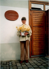 Eliška před obnoveným Obecním domkem, dostala 60 narcisů k 60. narozeninám, 2004