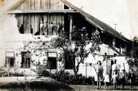 Rodiče Jana Tichého Josef a Božena s dětmi (vlastními i ze sousedství) před statkem v Porubě provizorně opraveném po bombardování / květen 1945