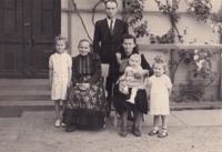 Anna Slanina se svou rodinou v prvním roce života, sedící na klíně