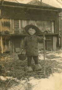 Malý Albín Huschka na dvoře jejich hospodářství v Ketzelsdorfu v pracovní obuvi, 1940