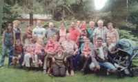 Petr (nahoře pátý zleva) se ženou Marujou (sedí na trávě) na rodinném setkání na Ždáni, Slapy, 2016