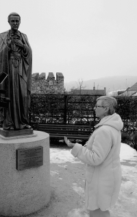 Marie Svatošová in front of the statue of St. John N. Neumann, patron saint of the Hospice in Prachatice
