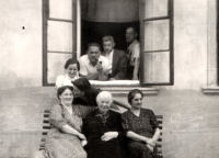 Lavička zleva: Malvína (zahynula v Rejowiec), Terezie (zahynula v Treblince), Žofie (zahynula ve Varšavě), u okna: Margareta Bardachová, s dýmkou Armin Grünwald (zahynul v Izbice), děda Leo a Mořic (zahynul ve Varšavě)