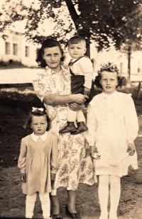 Marie Štráchalová (vlevo) se sestrou Jarkou, matkou Marií Pavelkovou a bratrem Vašíkem v sadě v Záblatí (1949)