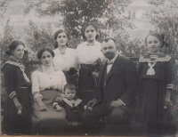 Emílie Veverková s rodiči a sestrami: stojící zprava Riči, Aninka, Pepi, Boženka. Sedící rodiče a Emílie (4 roky), 1916