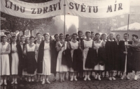 Marie (první vpravo) s tyčí k transparentu. Prvomájový průvod se spolužačkami ze střední zdravotní školy, Praha, 1. května 1953