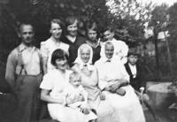 Asi šestiměsíční pamětnice v náručí své matky s příbuznými a známými / 1934 