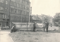 Petr Miller (napravo) vyvěšuje transparent proti sovětské okupaci