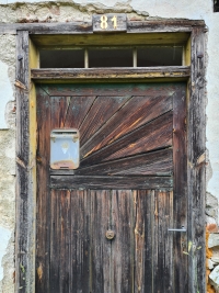 Vstupní dveře do domu ve Chvalšinách č. 81, kde Sýkorovi bydleli během války, 2021