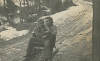 Erna Demuth riding on a sledge with a friend