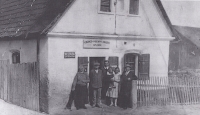 Jan Žáček's convenience store in Radostovice, the gradfather of the witness, the witness is held by her parents in the photo. From the left: grandmother and grandfather Žáček, uncle Stanislav Žáček, witness with mother and father Josef Žáček, ca. 1931