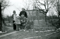 Stojící maminka pamětnice se synem Jirkou a jeho dětmi na zahradě na Pšovce, 1977