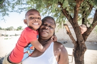 Vašek s jedním ze svých dětí před svou farmou nedaleko Windhoeku v Namibii, 2021
