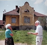 Irma a Victor, sourozenci, před domem, kde rodina bydlela po válce, 1999