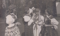 Věra Domincová s děvčaty z Hradišťanu, šátek se váže pamětnici Věře Heidlerové, 1956