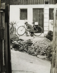 Karel Hajn před domem v Paceřicích v roce 1986. Opravuje kolo, na kterém pamětnice jezdila ještě v roce 2022