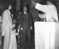 Baptism of Kateřina Moravcová, Marta Kubišová's daughter, in the church of Apostle Jacob the Elderin Štoky. Marta Kubišová (left) holding her daughter's hand; the godfather, Václav Havel (left; wearing a jacket); Father Josef Jakubec (right) Štoky, 1983