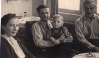 Zleva maminka Marie Bartošová, Jiří Štokman na klíně s pamětníkem, vpravo jeden z převaděčů Ludvík Holobrádek, v německém domě Bartošů, 1950 