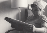 Maminka Marie Burešová čte noviny před odchodem do práce