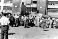 Uprchlický kemp v Bagnoli, Itálie, pamětník nalevo zády, lidé odjíždějící kamsi do dalšího kempu.