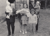 Křtiny dcery Marcely, kterou drží švagrová Vlasta, vlevo manžel Jiří nese syna Jiřího, Hostinné, 1971