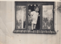 Ve dvou letech v okně bytu v domě v Schnellau (Slaném), kde žili s prarodiči z tatínkovy strany, 30. léta