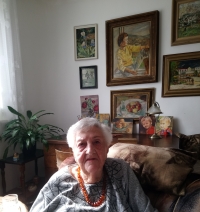 Maria Čachová (v pozadí obrazy, které maloval manžel), Zlín, 2023 