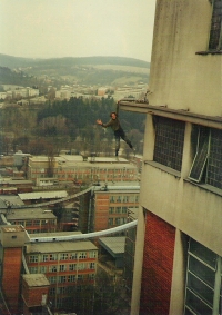 Jan Rozsypal hanging on one arm from the skyscraper Jednadvacítka, 1990