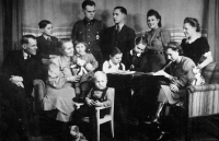 Rodinné foto Moudrých, zleva: otec Richard, matka, sestry Markéta, Marianna, Helena a Linda, pamětník v popředí na židli. Nahoře bratři Horst, Georg, Reinhard, sestry Elizabeth a Elfriede