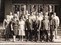 Před administrativní budovou JZD Pokrok v Oticích. Zdenka Pospíšilová stojí úplně vlevo v puntíkovaných šatech, po její levé ruce stojí předseda JZD Antonín Vincker. Fotografie z poloviny 80. let dvacátého století