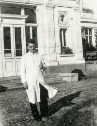 Otec Zdenky Pospíšilové Josef Vyskočil v bílém plášti jako úředník Zemské nemocnice v Opavě před nemocniční administrativní budovou, 30. léta dvacátého století