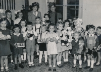 Děti zachráněné Přemyslem Pitterem na návštěvě u Hany Benešové. Judis Urbanová v kostkovaných šatech s medvídkem v ruce je třetí zprava ve druhé řadě, 1947