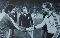 Ladislav Vízek si jako kapitán československé reprezentace podává ruku se svým západoněmeckým protějškem, jímž není nikdo jiný než legendární střelec Karl Heinz Rummenige. Hrálo se na podzim 1985 na Olympijském stadionu v Mnichově, Československo remizovalo 2:2