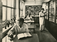 Promotional postcard showing the library of the pharmaceutical company Galena in the 1960s. The library was later adapted into Ladislav Cvak's office, where he worked for 30 years. Standing on the right is Tomáš Elis